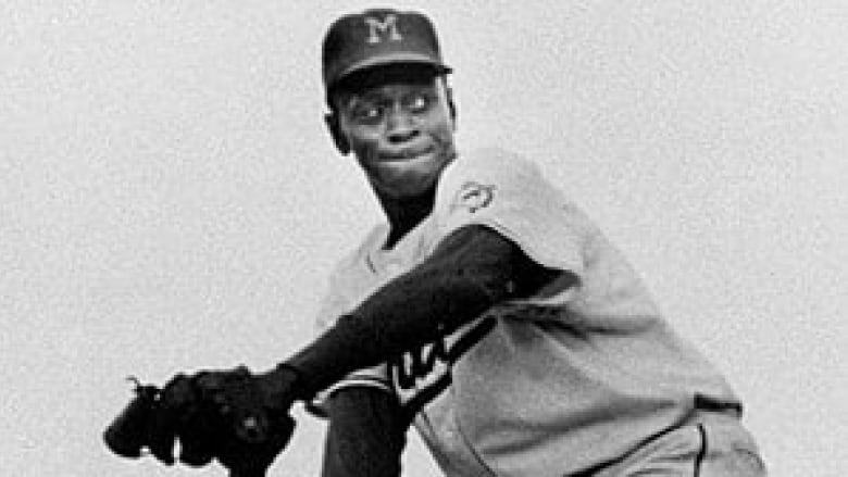 A black and white image of a man playing baseball.