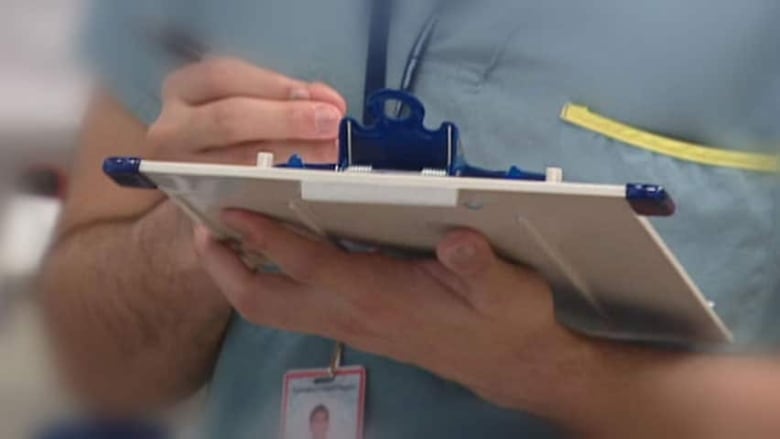 A doctor holds a clip board