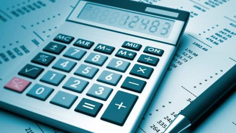 A calculator is shown over tax papers.