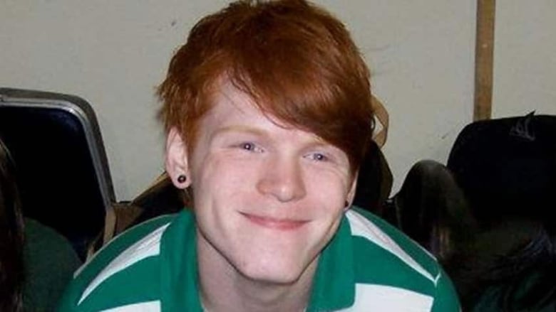 A smiling young man with red hair 