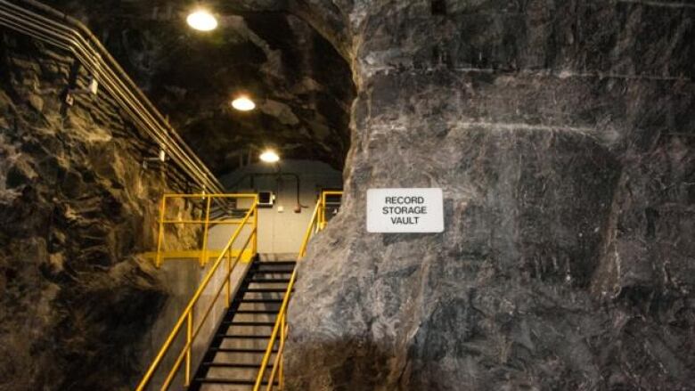 An image of the Churchill Falls power plant, located underground. There's a large wall with a staircase going up.