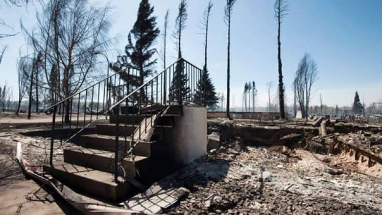 The wreckage of a burned out home with only steps remaining. 