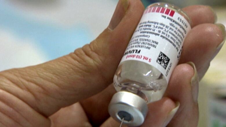 a syringe filling up with flu vaccine