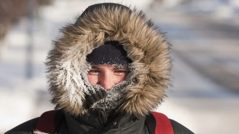 A person wears a parka to keep warm in cold weather.