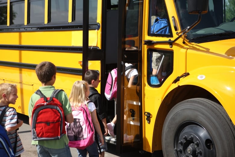 Kids getting on school bus.