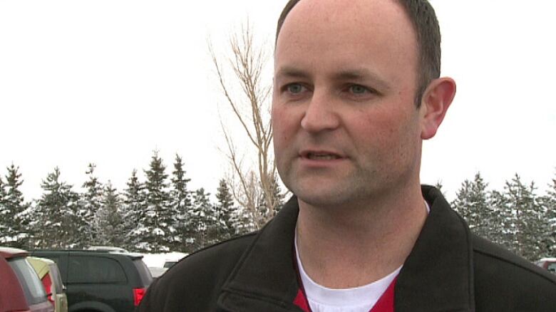 Craig Walsh speaks while standing outside.