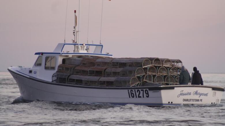 A lobster boat laden with traps.