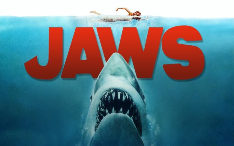 Movie poster for film, Jaws showing a shark under a swimming woman. 