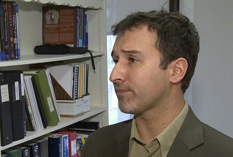 Dr. David Sabapathy in front of bookcase.