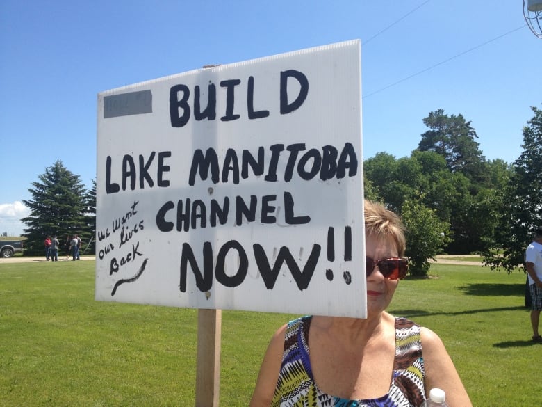 A woman holds a sign reading 