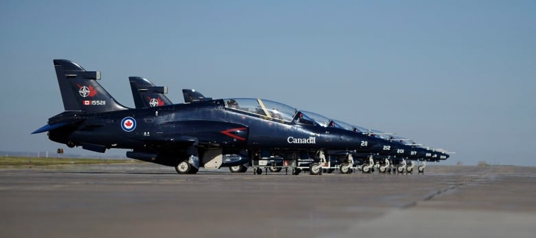 A row of dark CT-155 Hawk aircraft can be seen lined up at 15 Wing Moose Jaw, Sask.