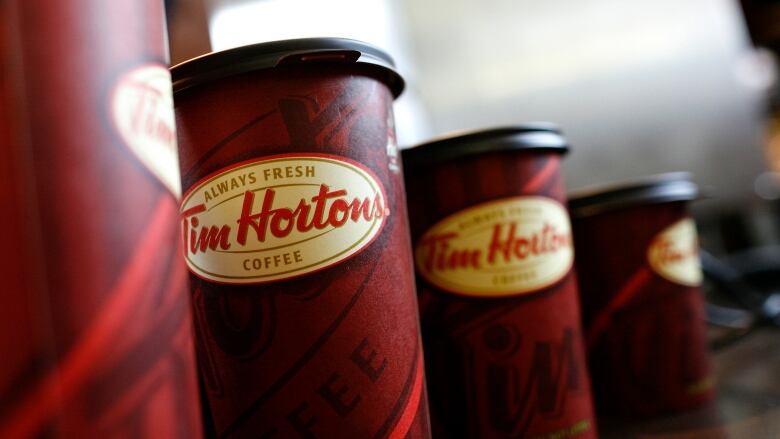 Four Tim Hortons coffee cups on a table.