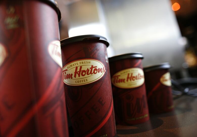 Four Tim Hortons coffee cups on a table.