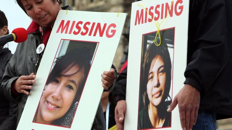 Woman holds a sign.