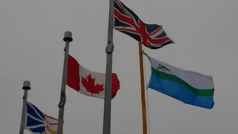 The Newfoundland Flag, The Canadian Flag, The Union Jack and the Labrador Flag raised alongside one another. 