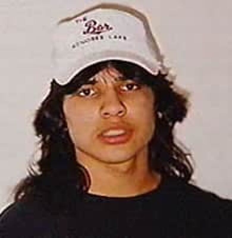 teen with long hair and ballcap