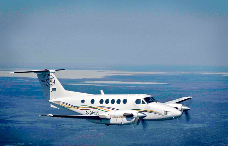 A small Missinippi aircraft flies through the air over the prairies.