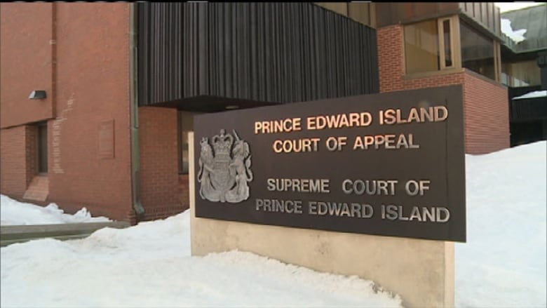 An outdoor sign for the Supreme Court of P.E.I. with snow surrounding it. 