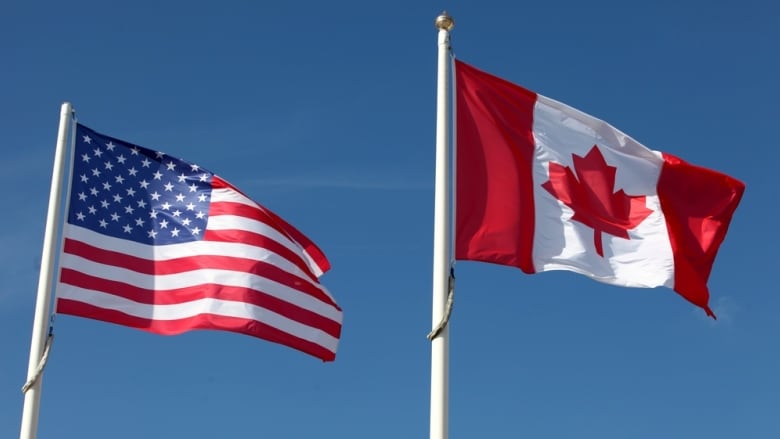 An American flag and Canadian flag fly side-by-side.