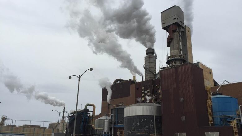 a building with smoke stacks on a cloudy day