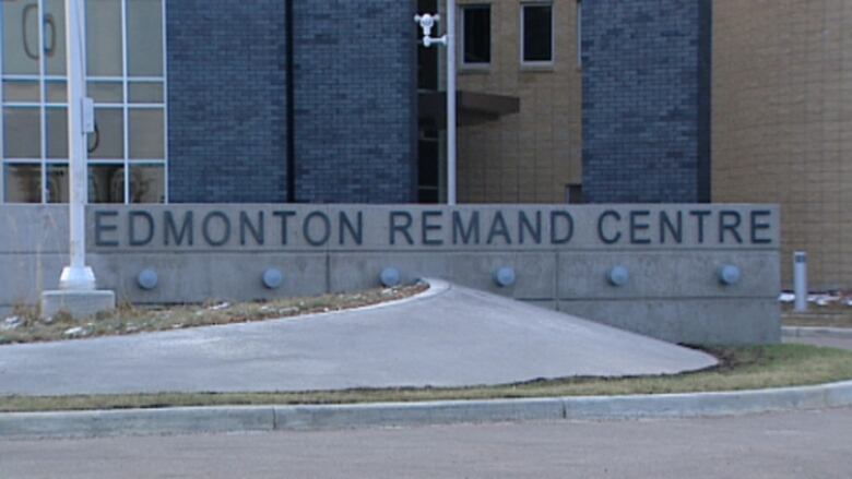 A view of a brick building with a concrete sign in front that says 