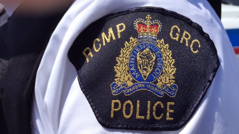 RCMP logo can be seen on an officers uniform. 