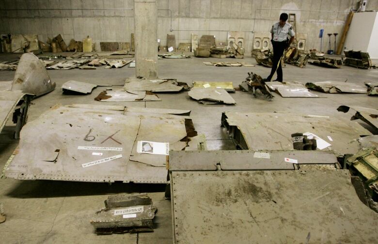 A member of the RCMP looks over airplane wreckage.