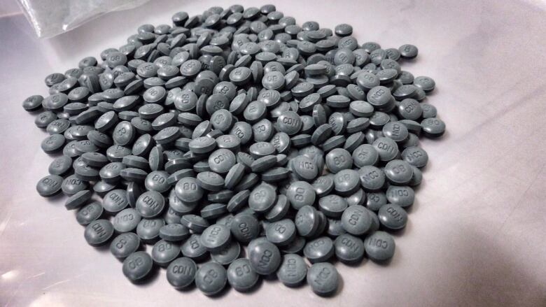 A pile of dark grey pills on a table