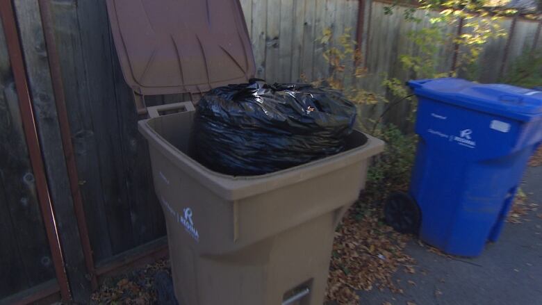 A brown bin with a bag in it.