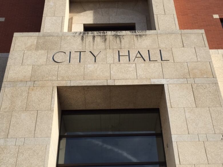 A grey bricked building labelled city hall.