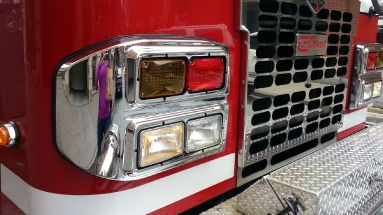 The front fender of a red fire truck is seen, up close.