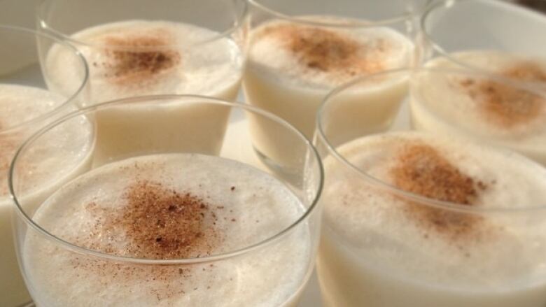 A tray of glasses with eggnog in them.