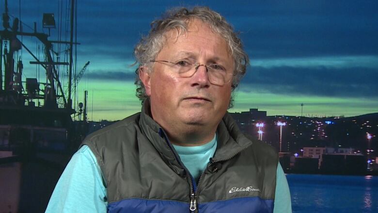 Dr. Ken LeDez standing in front of the ocean in Newfoundland. 