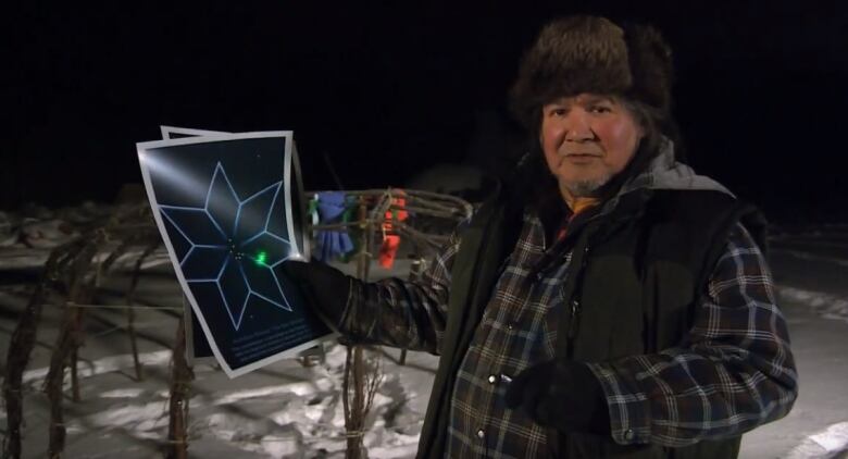 A man is pictured holding a picture of a star pattern.