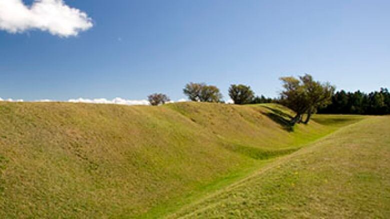 A grassy expanse shows indentations where old fortifications once stood. 