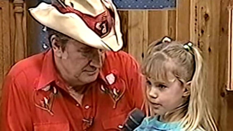 A man is pictured talking to a young girl.