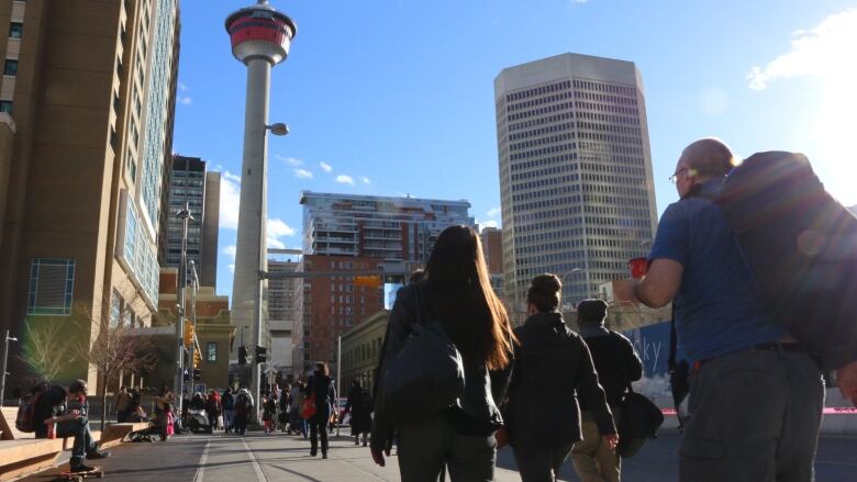 People walking in downtown Calgary towards the Calgary Tower. 