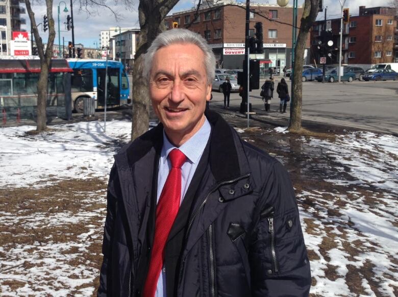 A man stands outside in a park.