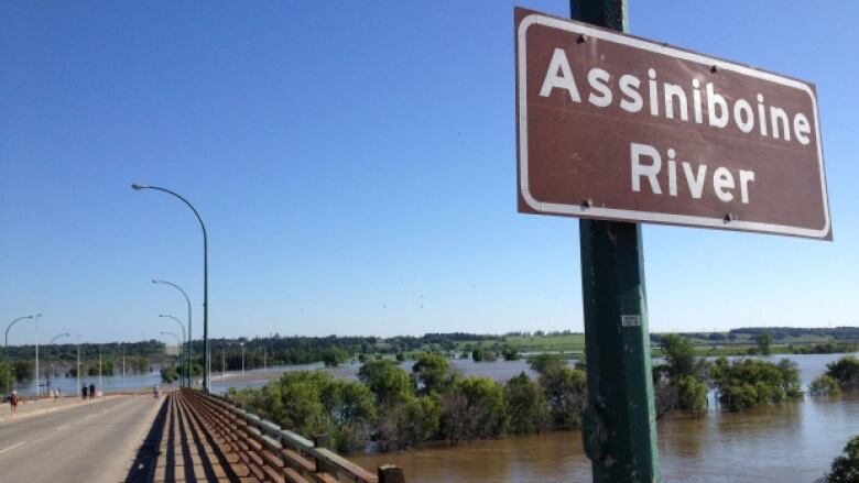 A sign that says 'Assiniboine River' is pictured.