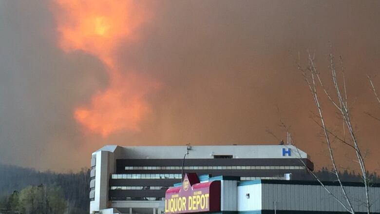 The Northern Lights Health Facility in Fort McMurray can be seen in this photo as flames shoot into the sky.