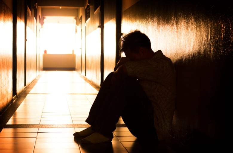 Boy sits on floor of detention centre.