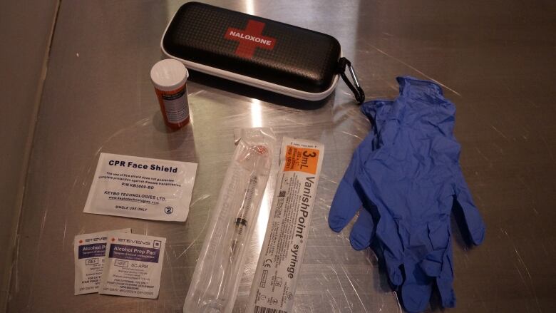 A take-home naloxone kit, a face mask and rubber gloves. 