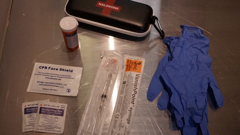 A take-home naloxone kit, a face mask and rubber gloves. 