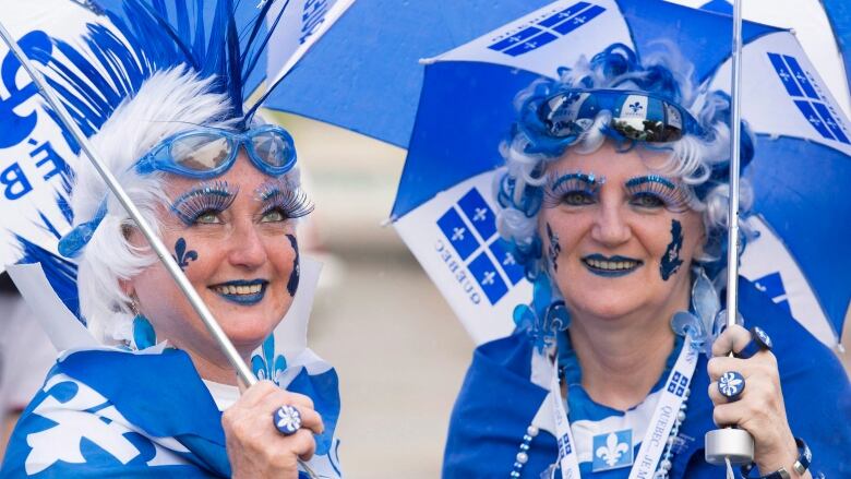 two women dressed up in blue and white accessories.