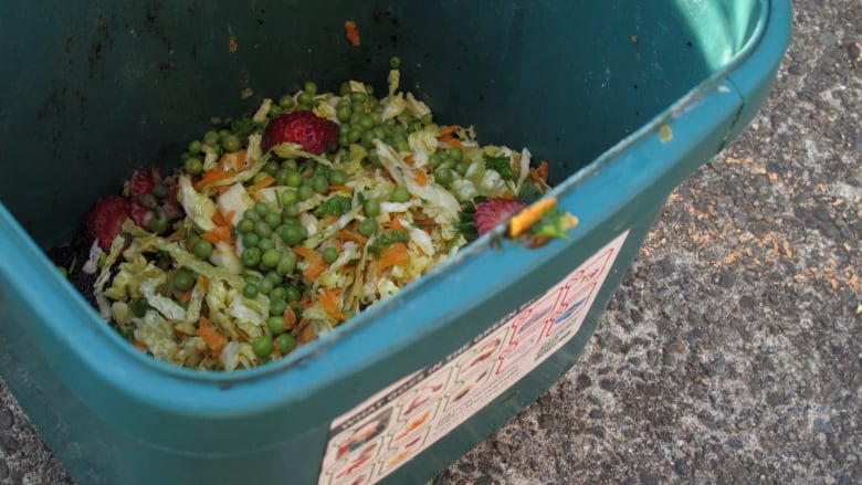 Green bin with food scraps inside. 