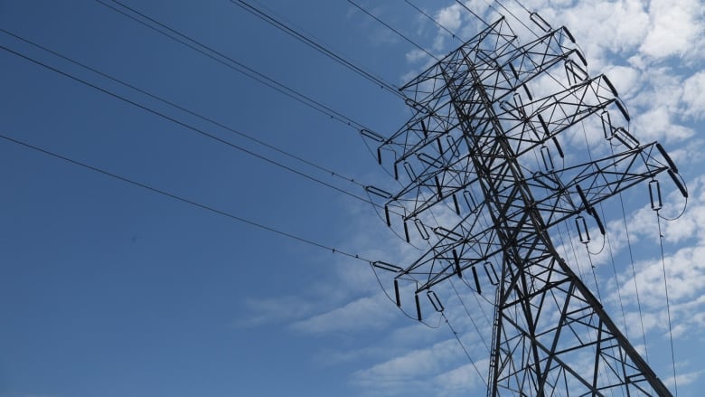 Power lines are show against a blue sky.