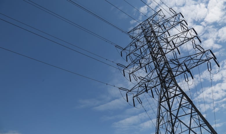 Power lines are show against a blue sky.