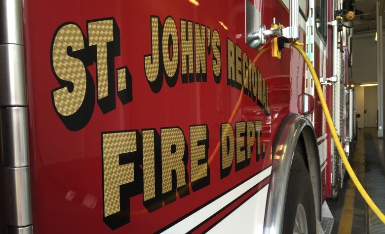 The side of a red fire truck, with the logo for the St. John's Regional Fire Department on it.