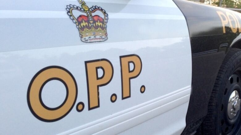 Medium shot of a police cruiser with the letters marked OPP, for Ontario Provincial Police. 