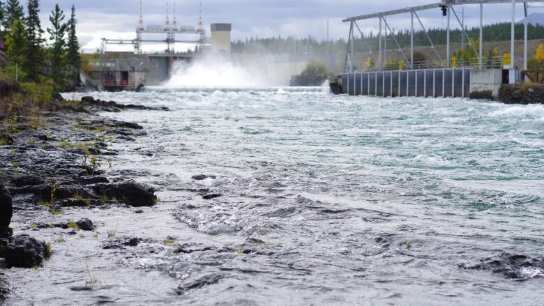 Water rushes through a power dam.